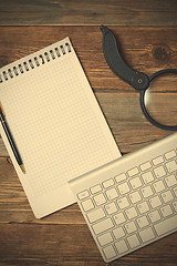 Image showing Computer keyboard, notebook, pen and magnifying glass