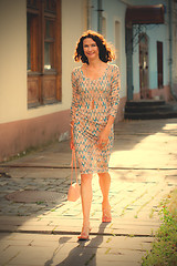 Image showing cheerful middle-aged woman walking on the street