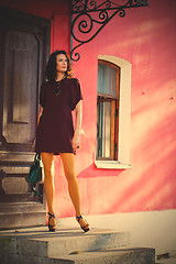 Image showing pretty middle-aged woman in a burgundy dress and pantyhose musta