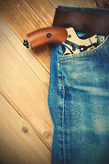 Image showing revolver nagant in the pocket of old blue jeans