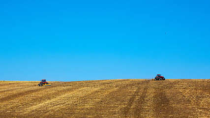 Image showing Agricultural Landscape. Tractors working on the field.