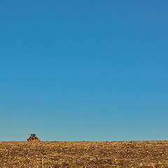 Image showing Agricultural Landscape. Tractor working on the field.