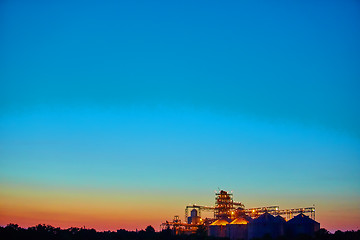 Image showing Agricultural Silo - Building Exterior, Storage and drying of grains, wheat, corn, soy, sunflower against sunset. 