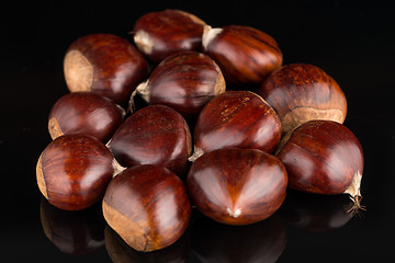 Image showing Chestnuts on a black reflective background