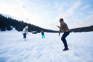 Image showing happy family playing together in snow at winter