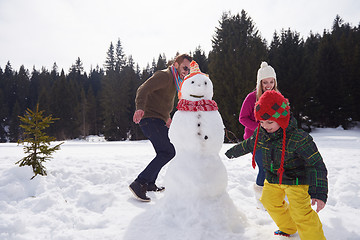 Image showing happy family building snowman