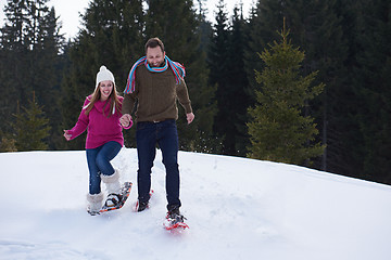 Image showing couple having fun and walking in snow shoes