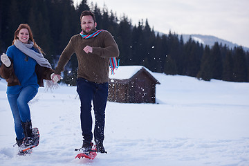 Image showing couple having fun and walking in snow shoes