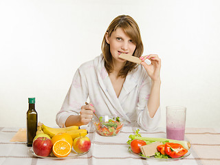 Image showing Young girl bites the bread, eating their vegetarian vegetable salad