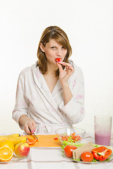 Image showing A young girl having fun eating a vegetarian pepper