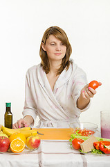 Image showing She picked up a tomato preparing a salad