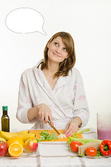 Image showing Housewife cuts vegetables for salad and dreamy looks at a cloud over his head thoughts