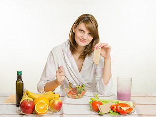 Image showing Young girl eats vegetarian vegetable salad and vegetable snack loaf