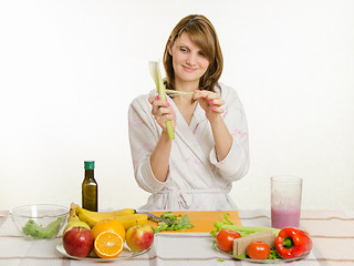 Image showing Happy housewife cleans celery