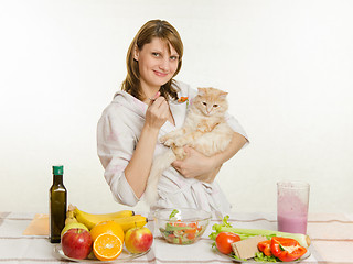 Image showing The young girl offers a vegetarian cat food