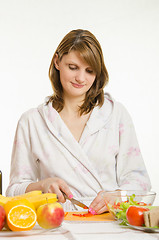 Image showing Woman cuts vegetables for salads