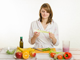 Image showing Happy housewife holding cooking celery salad