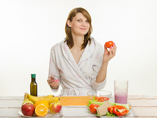 Image showing Happy housewife picked up a tomato salad cooking
