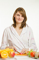 Image showing Portrait of a young girl who cuts vegetables for salads