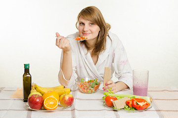 Image showing Young girl eats vegetarian vegetable salad with bread roll