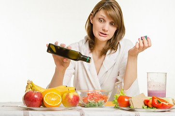 Image showing Young girl poured the oil into a vegetarian vegetable vitamin salad