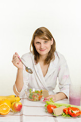 Image showing Young girl eating a vegetarian salad at the table