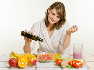 Image showing Housewife pours oil into a freshly prepared vegetable vitamin salad