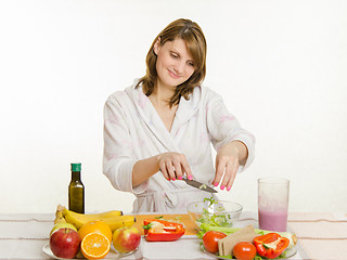 Image showing Housewife throws cutting in a cup of salad