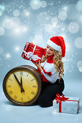 Image showing Girl dressed in santa hat holding with a Christmas decorations  