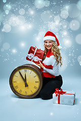 Image showing Girl dressed in santa hat holding with a Christmas decorations  