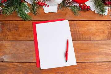 Image showing The blank sheet of paper on the wooden table with a pen 