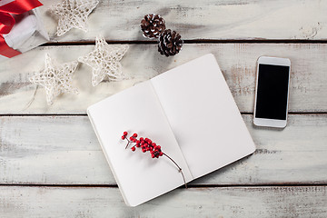 Image showing The open notebook on the wooden table with a phone