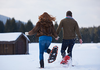 Image showing couple having fun and walking in snow shoes