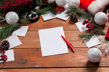 Image showing The blank sheet of paper on the wooden table with a pen 