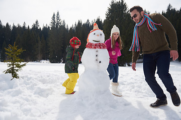 Image showing happy family building snowman