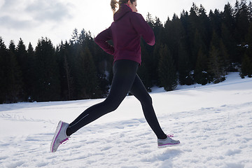 Image showing yougn woman jogging outdoor on snow in forest