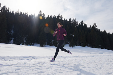 Image showing yougn woman jogging outdoor on snow in forest