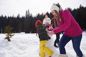 Image showing happy family building snowman