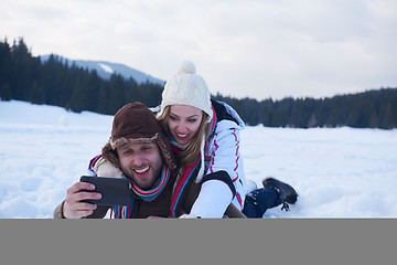 Image showing romantic couple have fun in fresh snow and taking selfie