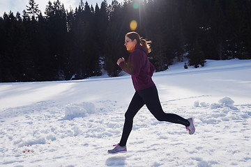 Image showing yougn woman jogging outdoor on snow in forest