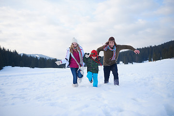 Image showing happy family playing together in snow at winter