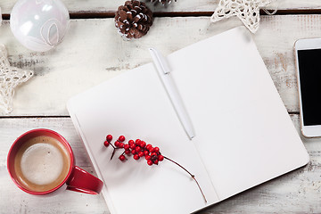 Image showing The open notebook on the wooden table with a phone