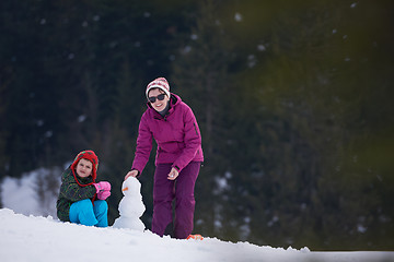 Image showing happy family building snowman