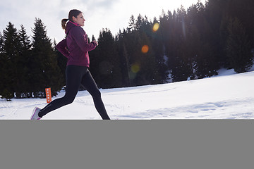 Image showing yougn woman jogging outdoor on snow in forest