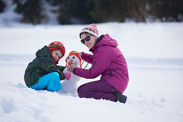 Image showing happy family building snowman