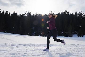 Image showing yougn woman jogging outdoor on snow in forest