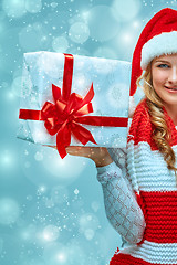 Image showing Girl dressed in santa hat with a Christmas gift 