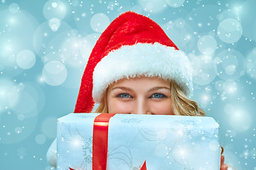 Image showing Girl dressed in santa hat with a Christmas gift 