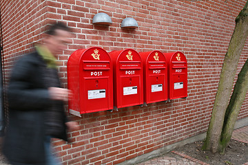 Image showing Man and postboxes on a brick wall