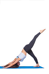 Image showing Studio shot of a young fit woman doing yoga exercises.